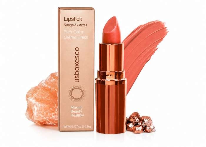 Luxurious rose gold lipstick with a warm coral shade, paired with matching swatch and elegant packaging.