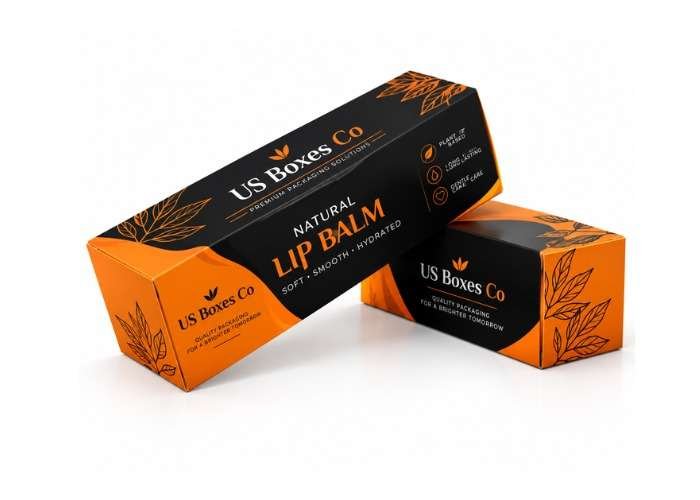 Black and orange lip balm packaging boxes with botanical leaf designs on a white background.